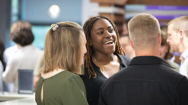 Students and alumni talking together at an event on campus