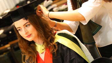 Staff member helping with robing