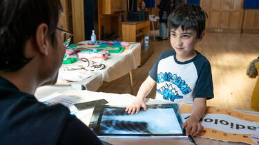 Small boy interacts with X Ray images at community outreach event