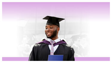 A male student in graduation robes