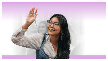 A female student raising her hand in class