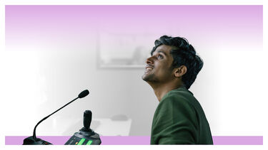 A male student at a console with a microphone