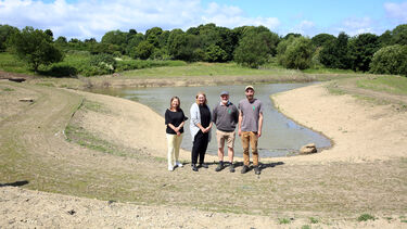 A team of 4 people standing by a basin in a park.