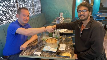 Feroz and Andrew Lofthouse sharing a meal in a restaurant.