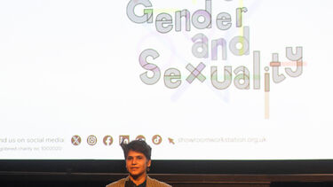 A member of staff is presenting in front a cinema screen with the words 'gender and sexuality' on the screen