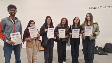 Group of students in line holding certificate for photo