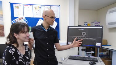 Clinician using a scanner to display a map of a patient's skin on a screen.