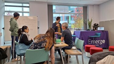 Students sat round table discussing enterprise 