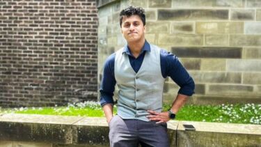 Arjun Nair sat on a wall outside the Management School.