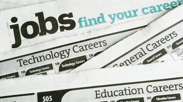 Jobs sections of various newspapers placed on top of each other