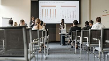 A higher education classroom with students and female academic staff