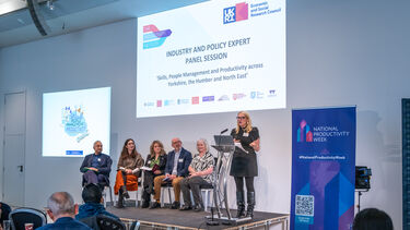 A panel of people sat on a small stage.