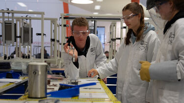 Three students conducting experiments in the structures lab