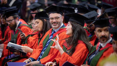 PhD students in hall looking happy