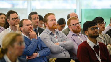 Several individuals listening to a conference presentation