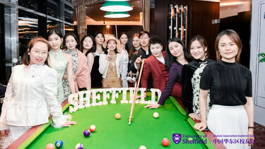 Alumni in Shanghai gathered around a pool table