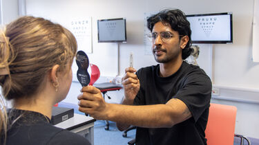 An orthoptics student gives an eye test to a volunteer