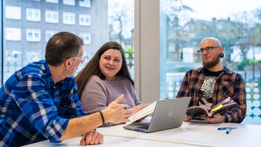 3 mature students working in the library
