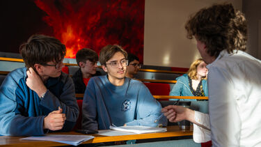 Lecturer explaining maths problem to students