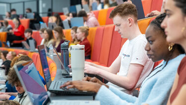 Students on laptops in the lecture theatre