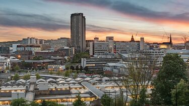 Sun setting over Sheffield train station and various tall office buildings