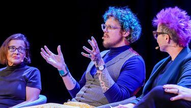 Dr Denis Newman-Griffis sat on stage and talking as part of a panel discussion