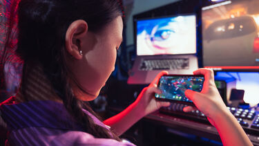 A teenage girl playing a video game on her phone