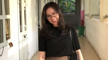 Hailey stands in a hallway smiling 