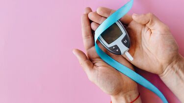 Glucose monitor on a pink background.