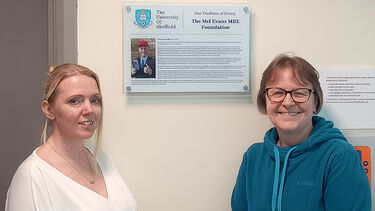 Laura Ellis and Lynn Pritchatt standing beside a Mel Evans plaque at SITraN
