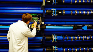 A man in the Sheffield Water Centre in front of large pipes 