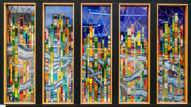 Five portrait-oriented slim stained glass windows showing multicoloured stripes and waves