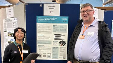 Aerospace student with lecturer standing in front of a poster on electric curing