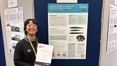 Aerospace student standing in front of her poster on electric curing