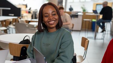 Student sat smiling at desk