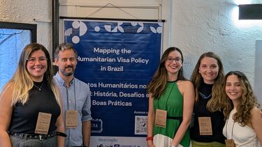 Picture of the research team (5 people) with a banner
