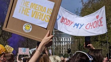 Antilockdown protest with banners stating 'The media is the virus'