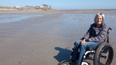 An image of Ruth in a wheelchair on a beautiful British beach