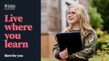 Student smiling holding laptop 