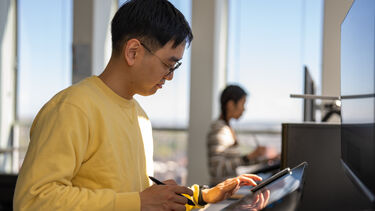 Student using digital technology in Media Unit to design 