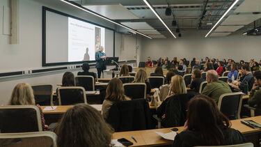 A man giving a presentation to a room full of people at a conference