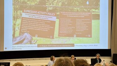 Margaret Price presenting in front of a large lecture theatre.