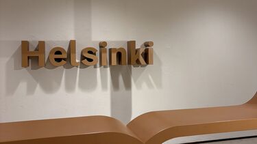 A wooden art piece of the word Helsinki framed by a speech bubble. 