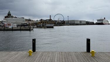 A view of the water of Helsinki Harbour. The SkyWheel and buildings can be seen in the distance. 