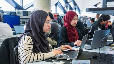 2 girl students coding in lab