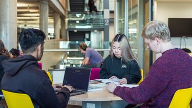 Three students study in the Information Commons 