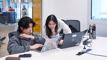 2 students looking at laptops