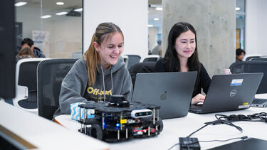 2 girl students coding waffle robots