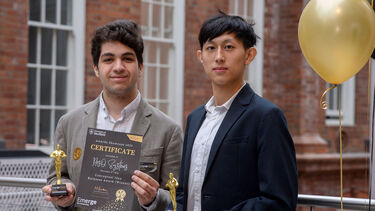 two student founders standing with certificate