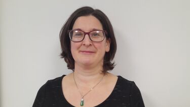 A woman with short dark hair and glasses